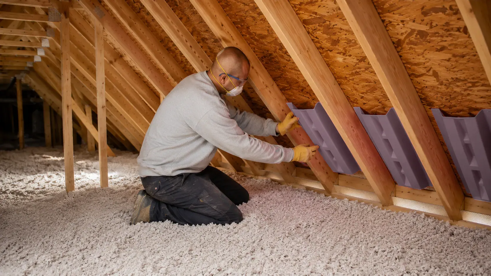 Batt insulation being fitted between framing members