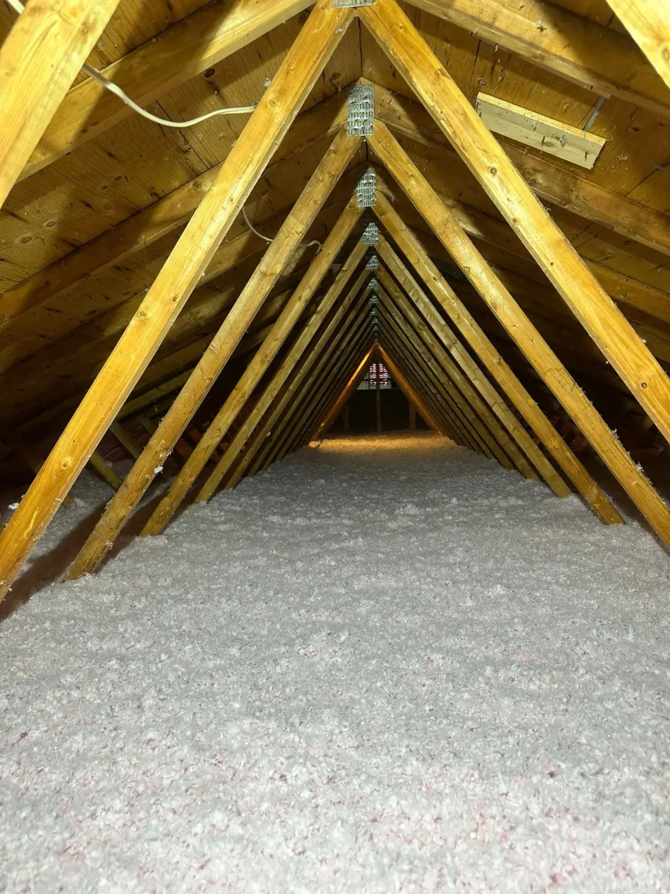 Existing insulation across an attic floor, seen between the ceiling joists