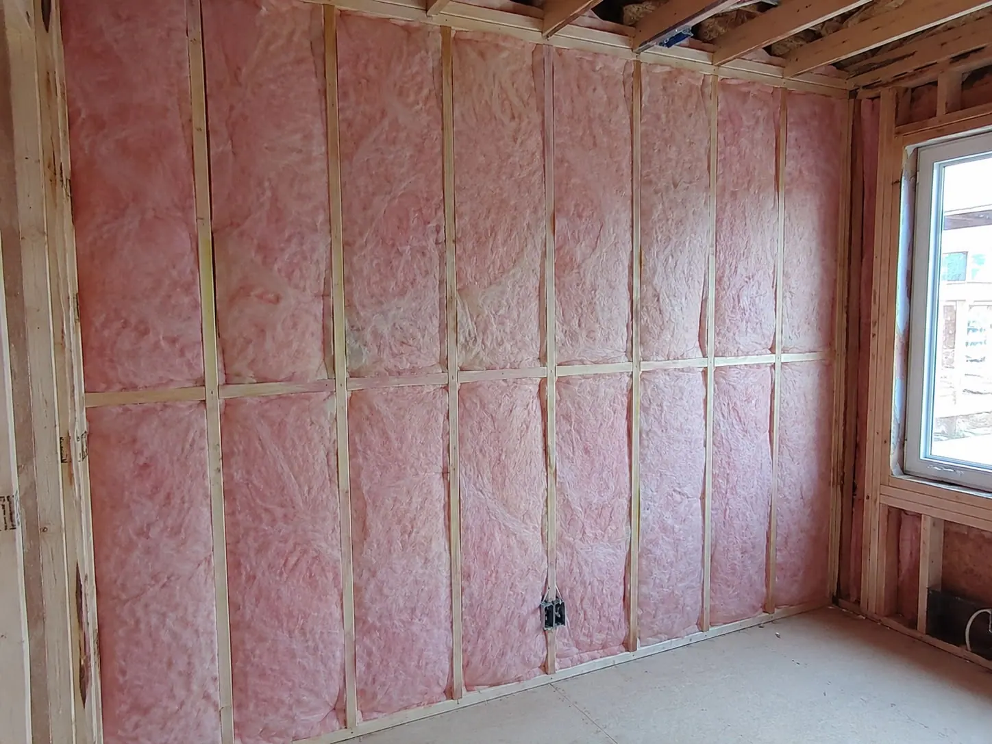 Insulation batts installed in a basement wall assembly